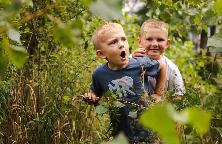 Kinder auf Entdeckungstour im grünen Dickicht des Naturerfahrungsraums im Park am Gleisdreieck