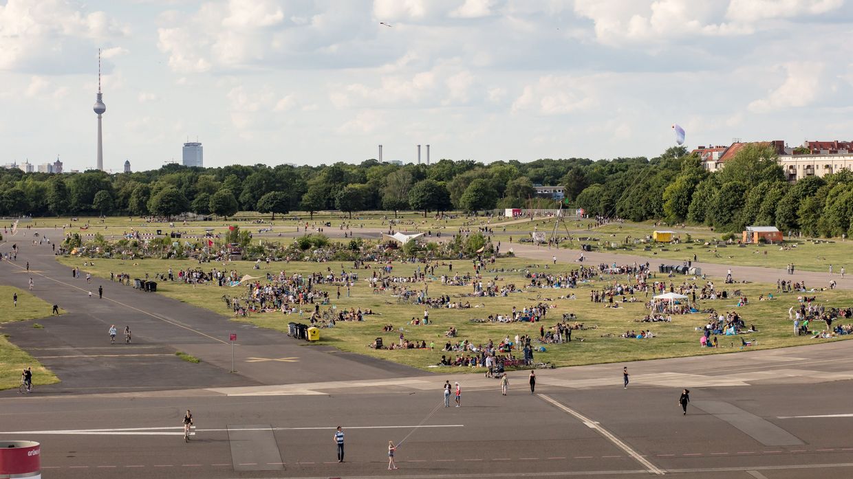 Ein Blick auf das Tempelhofer Feld aus der Vogelperspektive, viele Menschen versammeln sich auf der Wiese.