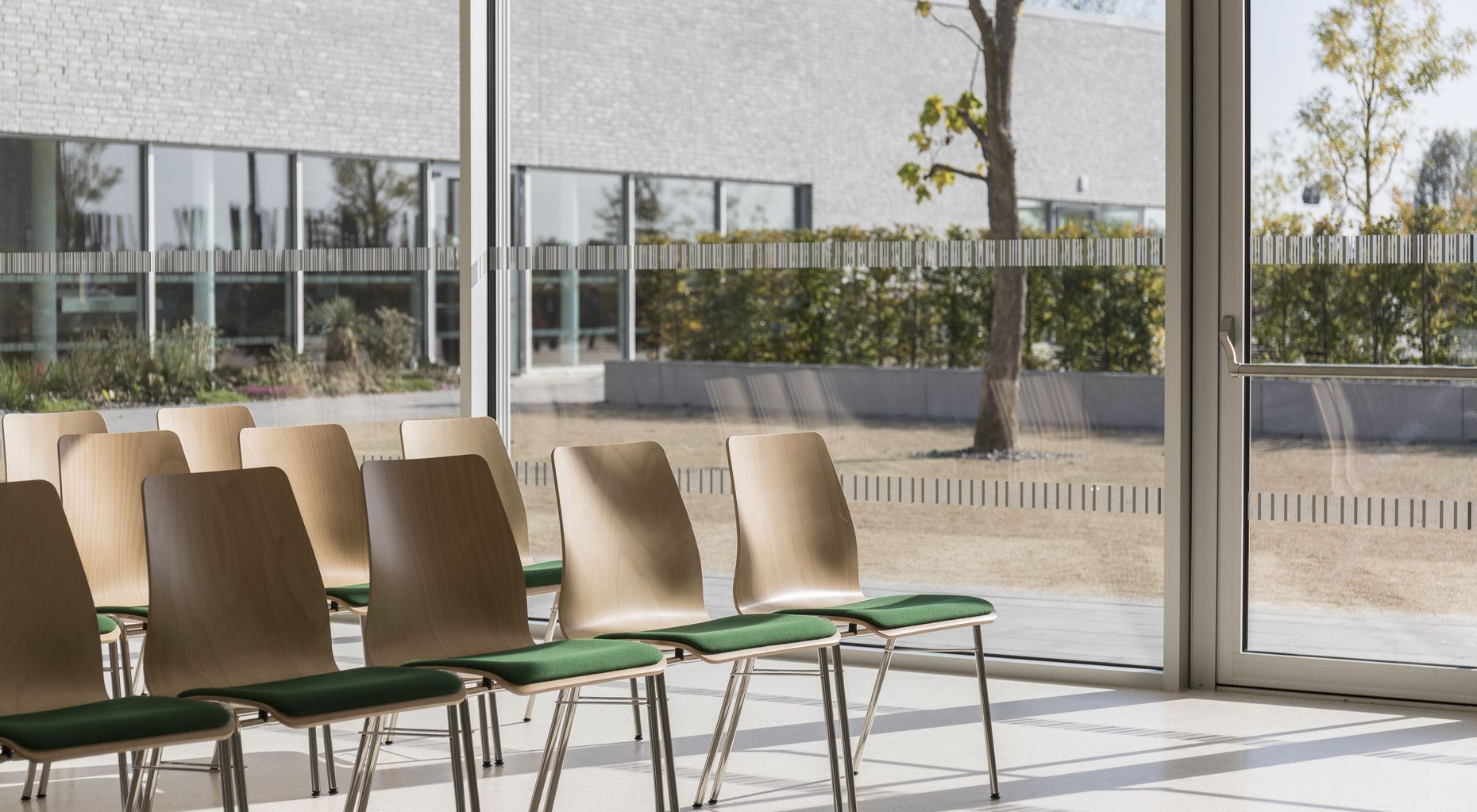 Stühle mit grünen Sitzkissen im Besucherzentrum der Gärten der Welt