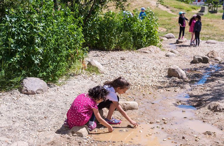 Kinder spielen am Wasserlauf des neuen Naturerfahrungsraum Tempelschlucht
