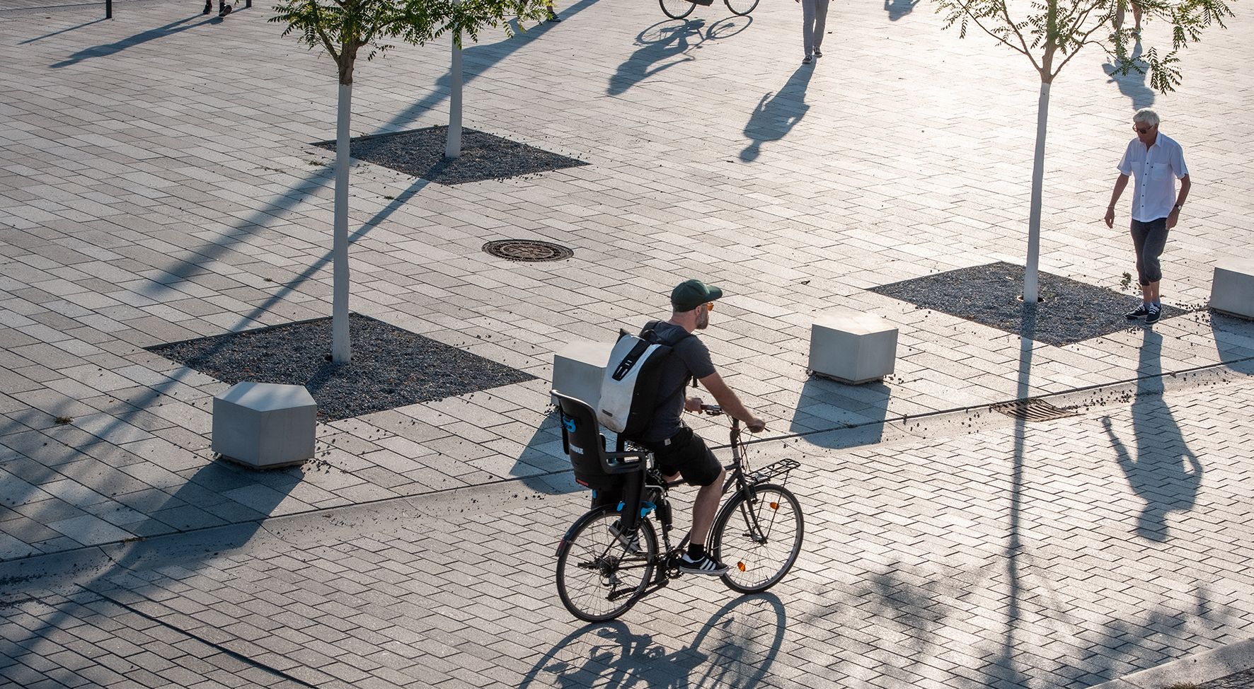 Das Bild zeigt einen Mann der mit dem Fahrrad über den neugestalteten Platz am Kulturforum fährt.
