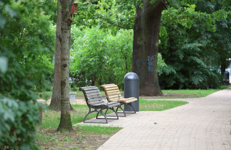 Zwei Holzbänke in grüner Umgebung an Parkweg