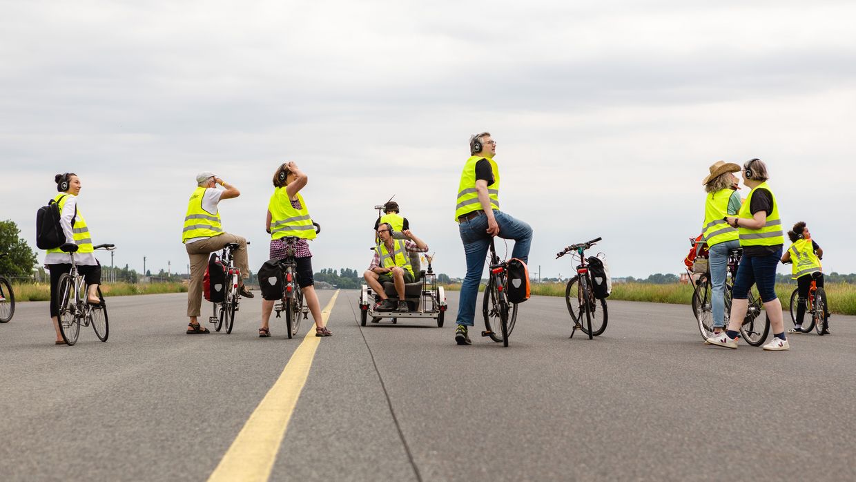 Menschen fahren auf Fahrrädern über die Landebahn des ehemaligen Flughafens Tegel