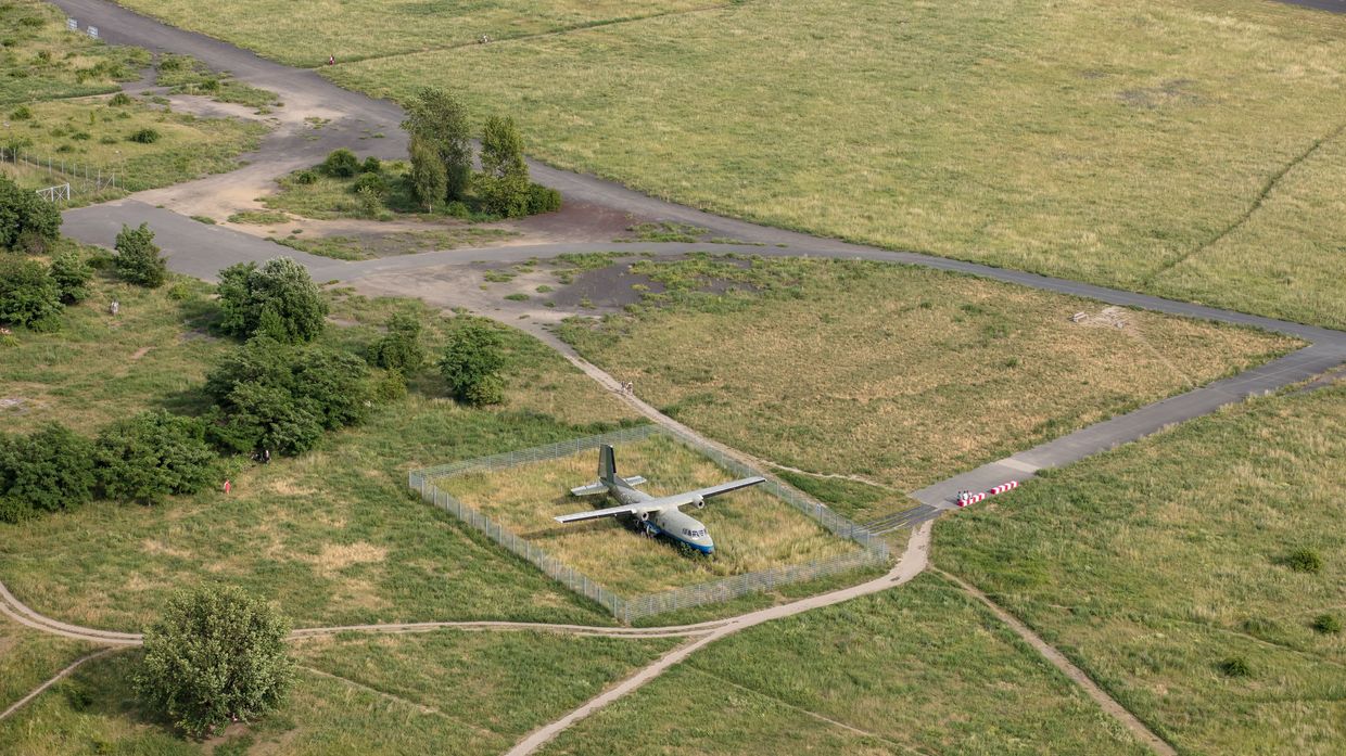 Luftbild eines alten Flugzeugs auf einer grünen Rasenfläche auf dem Tempelhofer Feld