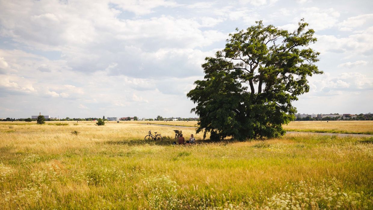 Zwei Personen sitzen auf einem Feld.