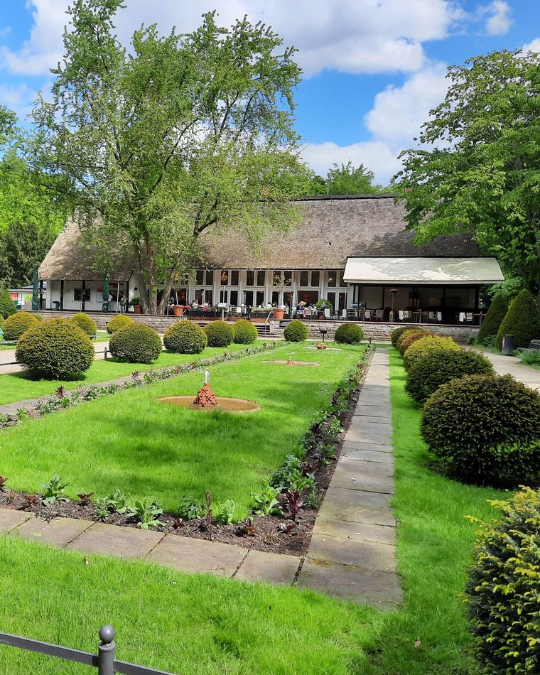 Das Teehaus im Englischen Garten des Tiergartens Berlin mit Vorgarten/Wiese.