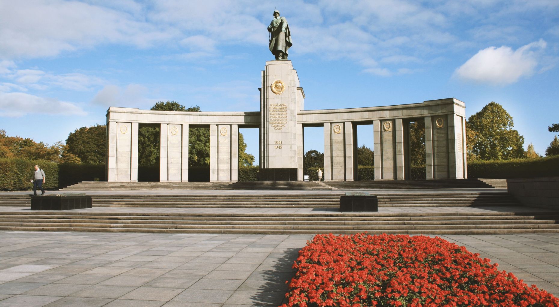 Das Bild zeigt das sowjetische Ehrenmal. Es ist eine große Statue zu sehen, sowie ein Blumenfeld.