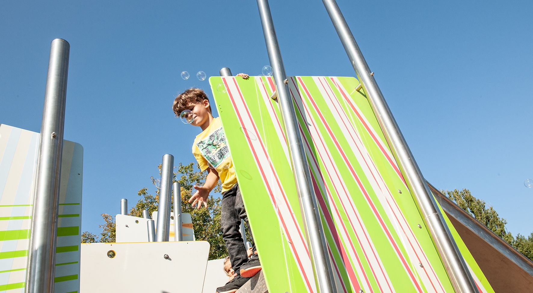 Das Bild zeigt einen Jungen auf einem Klettergerüst.